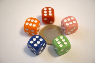Close-up of Hungarian 200 forint coin surrounded by colorful six-sided dice, concept of luck, wealth, and destiny.
