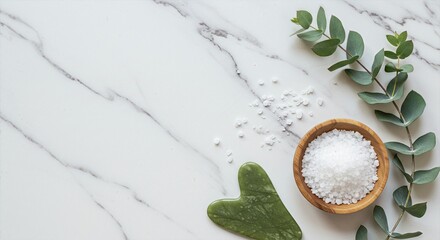 Clean Beauty Product Flatlay with Jade Gua Sha, Sea Salt, and Eucalyptus Branches on White Marble Surface