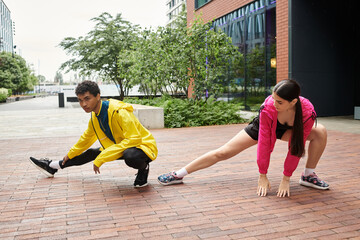 Sporty young duo stretching in an urban park during bright morning hours together