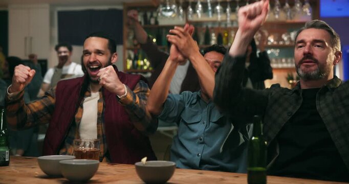 Man, friends and celebration at sports bar with fist pump, game and hug with drinks at social event. Person, group and crowd with scream, excited or motivation with watching tv for contest at pub