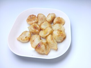 fried bananas or pisang goreng in white bowl. traditional indonesian snack. Isolated on white background
