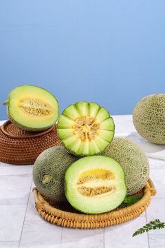 Fresh Hainan Reticulated Melons Cut in Half with Cream Flesh in Wicker Baskets