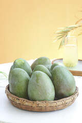 Fresh Green Mangoes in Wicker Basket with Tropical Drink Summer Still Life