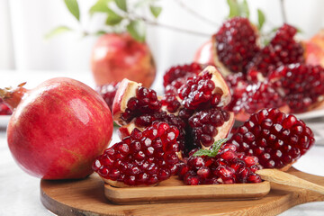Fresh Pomegranate Seeds and Fruit on Wooden Board - Healthy Organic Superfood Display