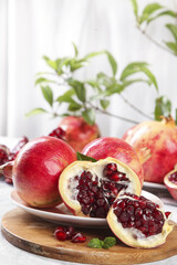Fresh Pomegranates with Red Arils on Wooden Board - Healthy Superfruit Display