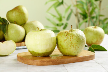 Fresh Jinshuai Apples from Shandong China on Wooden Board with Green Plant Background