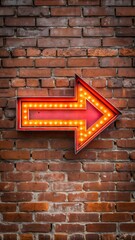 Obraz premium Glowing red arrow sign on brick wall illuminated sign