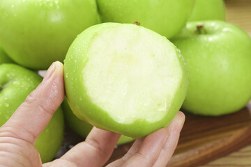 Hand holding fresh peeled green apple from Shaanxi China showing crisp sweet white flesh