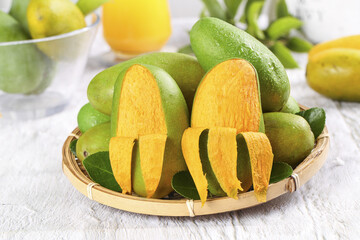Fresh Green Mangoes in Bamboo Basket with Sliced Golden Fruit Display
