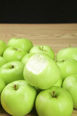 Fresh Green Apples with Bite Taken Out on Wooden Background - Healthy Organic Fruit
