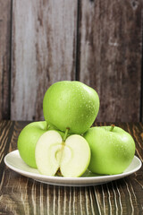 Fresh Green Apples with Water Droplets on Rustic Wood Background