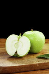 Fresh Green Apples from Shaanxi China on Wooden Board - Whole and Sliced Fruit with Water Droplets