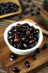 Black beans in bowl on wood cutting board - healthy legume ingredients for cooking