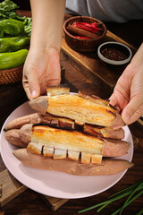 Roasted Sweet Potato Slices with Hands Presentation Traditional Asian Kitchen Setup