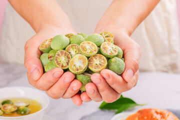 Fresh Green Kumquats in Hands - Citrus Fruit Collection with Tea Setup