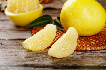 Fresh Sweet Pomelo Citrus Fruit Segments on Rustic Wood Background