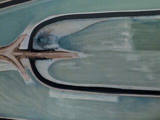 Aerial view of the Intrepid Potash evaporation ponds displaying an abstract pattern of turquoise waters and dark embankments, Moab, Utah, United States.