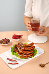 Traditional marinated duck feet with spicy seasonings and tea - Asian cuisine delicacy served on wooden table