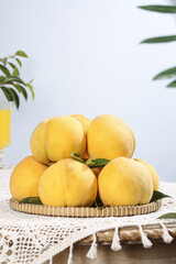 Freshly Picked Yellow Peaches on Wicker Plate with Juice Glass and Natural Styling