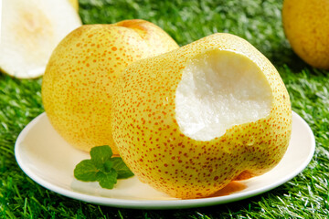 Fresh Crown Pears on White Plate - Golden Spotted Fruit Dessert with Mint Garnish