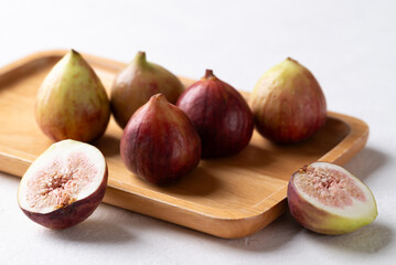 Fresh fig on wooden plate with white background, Autumn fruit