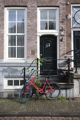 amsterdam canal house in the historical district with bike parked our front. facades of buildings, door of the building