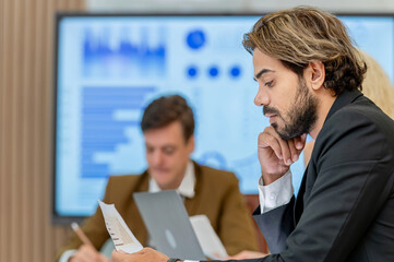 pensive businessman reading document in meeting