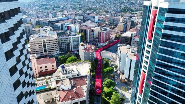 People carrying the Turkish flag for the national holiday celebration in Izmir - 4K video of the large Turkish flag and people carrying it, taken by drone, Izmir-Turkey and the celebration cortege