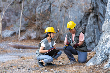 Two Female geologists working in the field mineral specimen by sampling hammer Rock collection by geologists in field, rock sampling in field research study data by observation rock inspection 