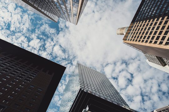 Skyscrapers in Frankfurt financial center seen from below, glass towers converging toward sky, perspective symbolizing progress, innovation and modern European architecture