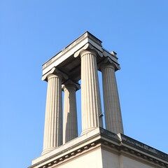 A large concrete column sits atop a building on a clear day.