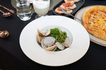 Seafood Pasta Delight: a beautifully styled photo of seafood pasta on a round, white plate with several tasty food around it. the appetizing look of the pasta is enough to make anyone's mouth water.