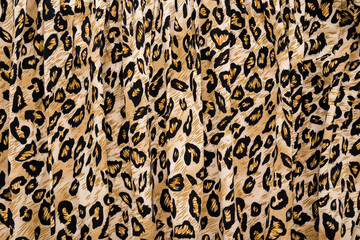 Dark black yellow soft wavy leopard spot pattern fabric background. Closeup. Top down view.