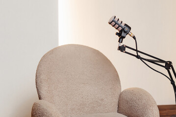 Cozy podcast setup featuring a stylish microphone and comfortable chair in a minimalist space