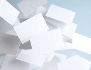 Blank white cards floating and scattered against a soft blue background, perfect for mockup designs, corporate identity, and creative branding presentations.

