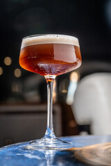 Elegant cocktail presentation at evening gathering. A vibrant cocktail in a tall glass, bubbling cheerfully, awaits at a social gathering.