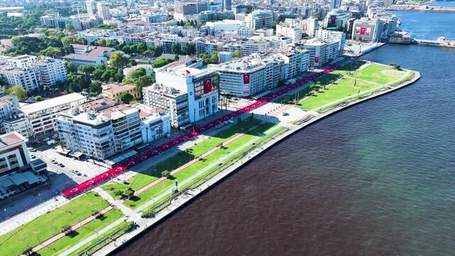 People carrying the Turkish flag for the national holiday celebration in Izmir - 4K video of the large Turkish flag and people carrying it, taken by drone, Izmir-Turkey and the celebration cortege
