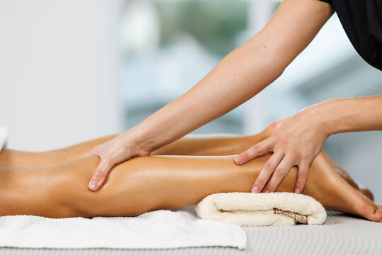 Lymphatic drainage massage of legs and lower legs. Female feet in the hands of a masseur.
