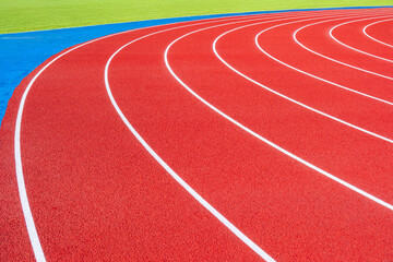 Fototapeta premium Empty running tracks at an outdoor athletics stadium featuring distinctive white lines and curves