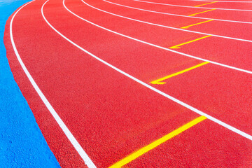 Fototapeta premium Empty running tracks at an outdoor athletics stadium featuring distinctive white lines and curves