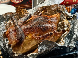Delicious roasted duck with crispy skin presented on foil in a baking tray ready to be served