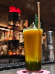 Refreshing tropical cocktail with ice and straw at a bar ready to be enjoyed on a warm evening