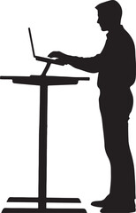 Silhouette of a man standing at a high desk using a laptop computer