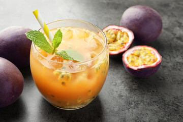 Tasty passion fruit drink with mint and fresh fruits on grey table, closeup