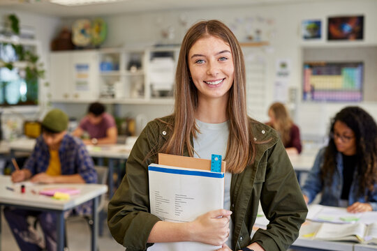 Smiling student girl in classroom at high school