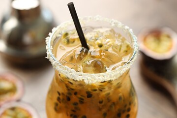 Tasty passion fruit drink in glass on table, closeup