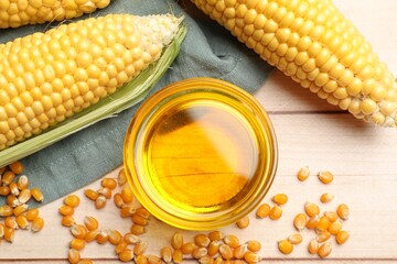 Corn oil, kernels and cobs on white wooden table, flat lay