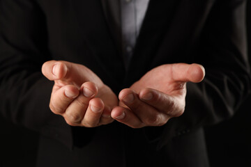 Obraz premium Man holding something on black background, closeup