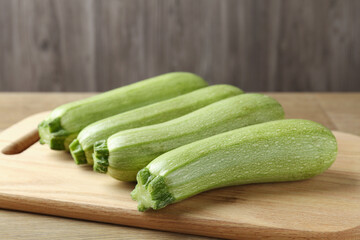Fresh ripe zucchinis on wooden table, closeup