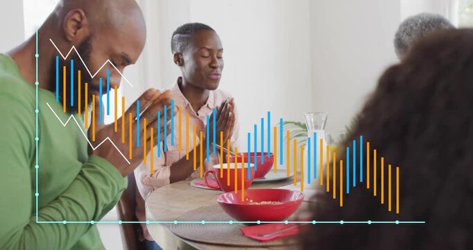 Mid adult man folding and bowing family blessing healthy breakfast then scooping cereal from bowls
